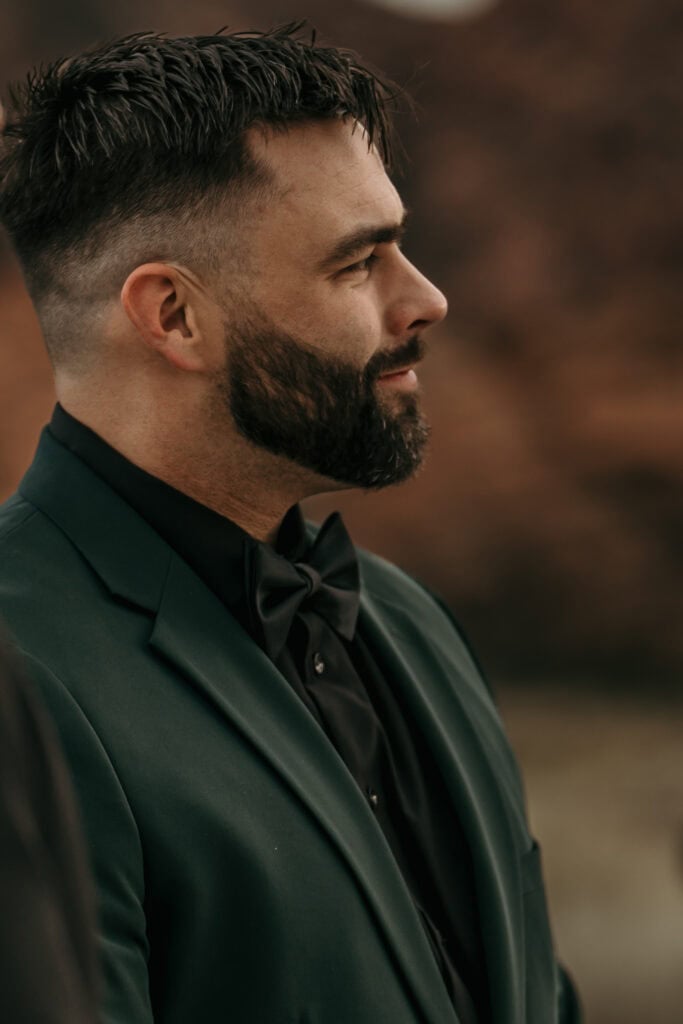 Groom looks on lovingly as the bride walks down the aisle towards him.