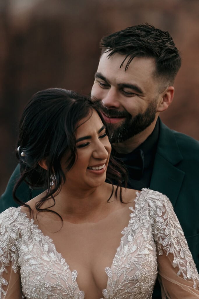 Bride and groom laugh together.