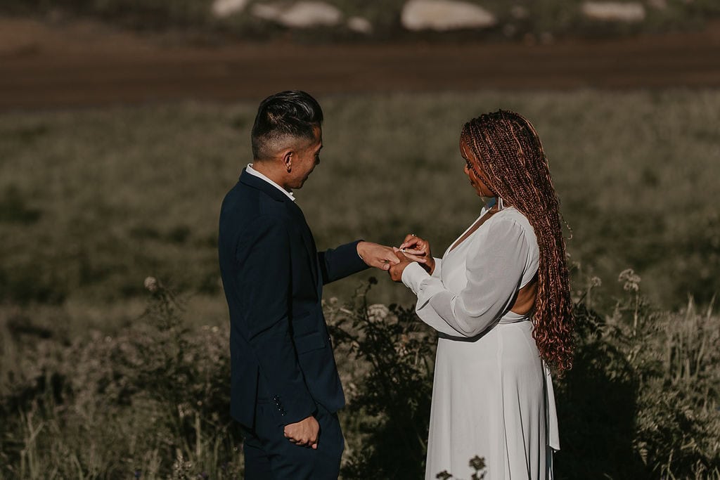 elopement couple exchanging rings during their wildflower field elopement ceremony in Crested Butte