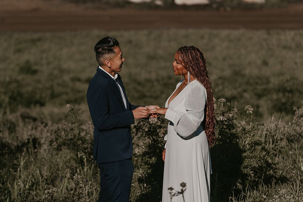 elopement couple exchanging rings during their wildflower field elopement ceremony in Crested Butte