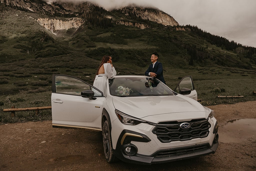 elopement couple posing with their jeep