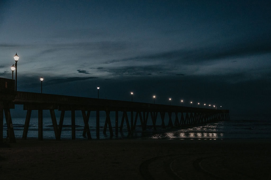 a Wilmington NC beach pier with lights during the night 