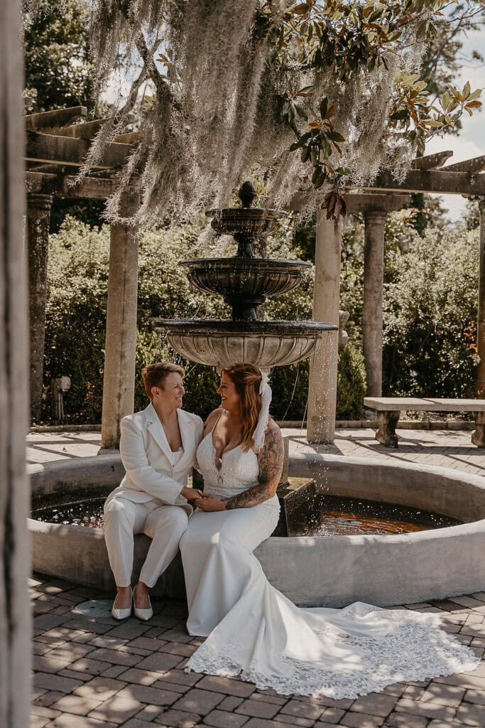 dreamy elopement couple sitting at a fountain structure at airlie gardens