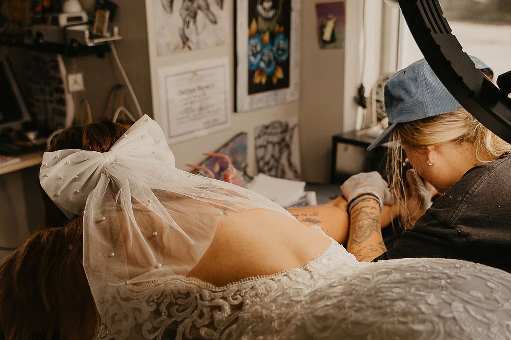 bride getting a tattoo done during the elopement day