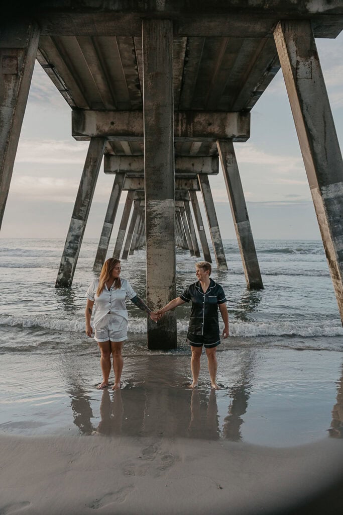 a playful couple playing with each other in the water at the beach in Wilmington NC