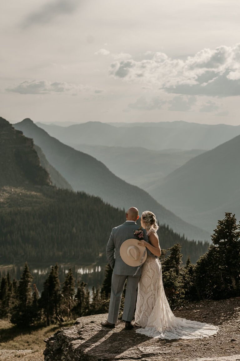 A bride and groom look out over the mountains during their elopement.