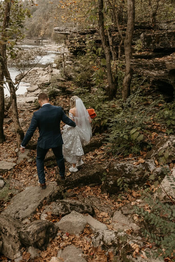 Eric helps Taylor navigate rocky steps during their outdoor hiking elopement.