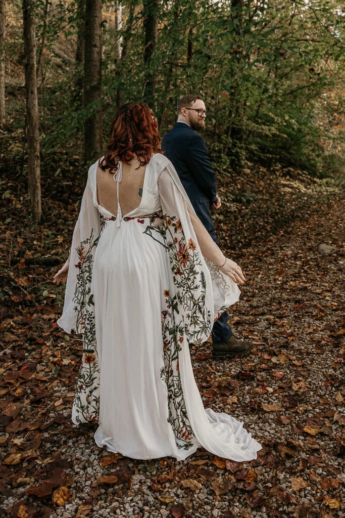 A man begins to turn to see his bride to be during the first look portion of the couple's outdoor wedding.