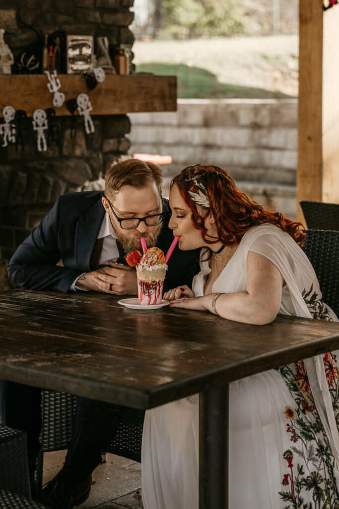 A couple drinks a cute milkshake at the same time during their elopement.