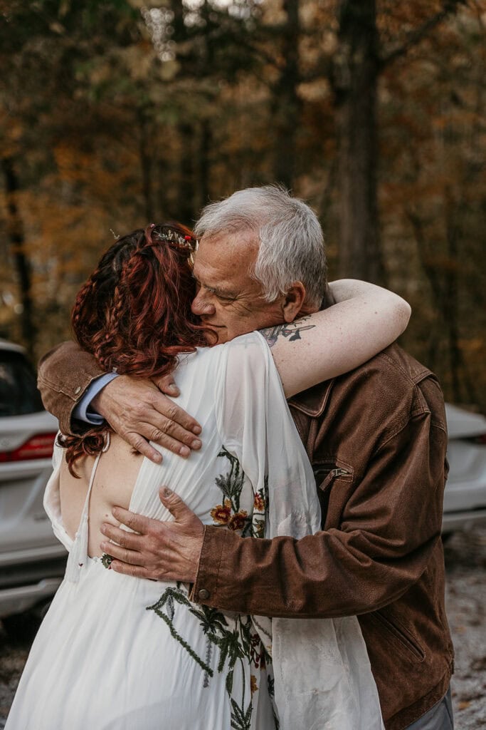 A man tenderly hugs a bride on her wedding day.